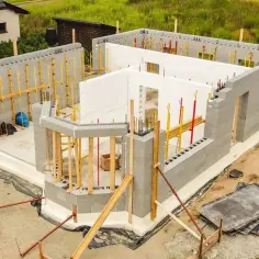 Budowa domu z bloczków betonowych, widoczne fundamenty i ściany.
