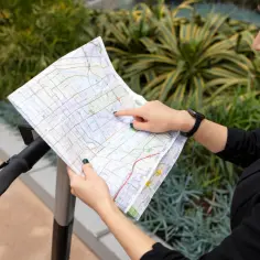 Kobieta z mapą w rękach, szukająca wskazówek, jak znaleźć działkę po numerze.