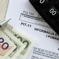 Pieniądze, długopis i formularz PIT-11. Zastanawiasz się, ile kosztuje u notariusza przepisanie działki? Sprawdź koszty transakcji.