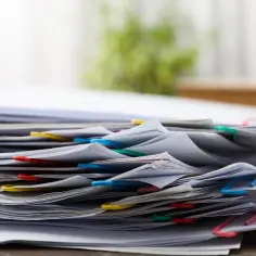 Stos dokumentów z kolorowymi spinaczami, gotowy do analizy w procesie zmiany warunków zabudowy.