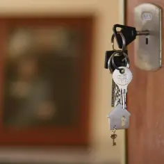 Pęk kluczy z breloczkiem w kształcie domu w zamku drzwi.
