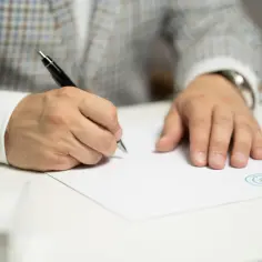 Mężczyzna w garniturze podpisuje dokument. Czy wniosek o wykreślenie hipoteki może złożyć jeden współwłaściciel?