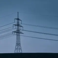 Wysoki słup energetyczny na tle błękitnego nieba. Zastanawiasz się, ile można dostać odszkodowania za słupy energetyczne?
