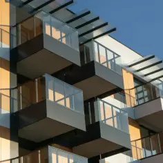 Nowoczesny budynek z balkonami i przeszklonymi balustradami. Zastanawiasz się, ile w Polsce jest mieszkań?