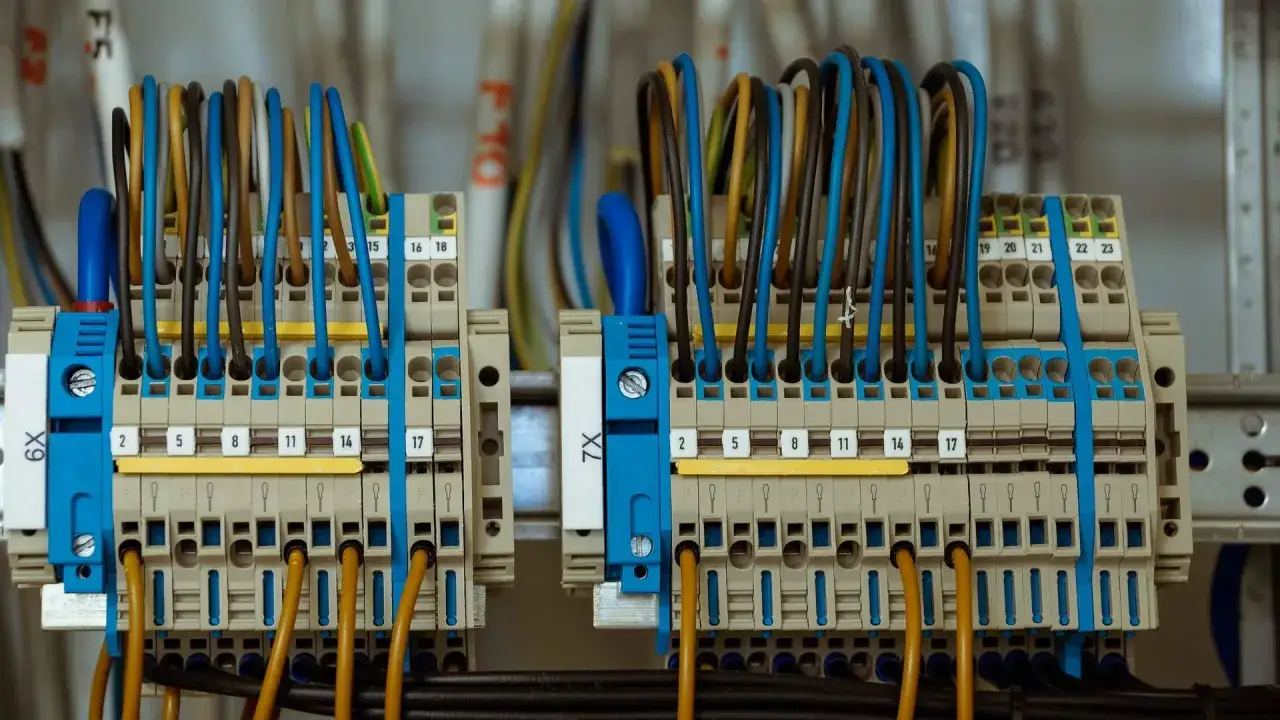 Zaciekawiło Cię, ile kosztuje przyłączenie prądu? Na zdjęciu widać szczegół instalacji elektrycznej z licznymi przewodami i złączkami.