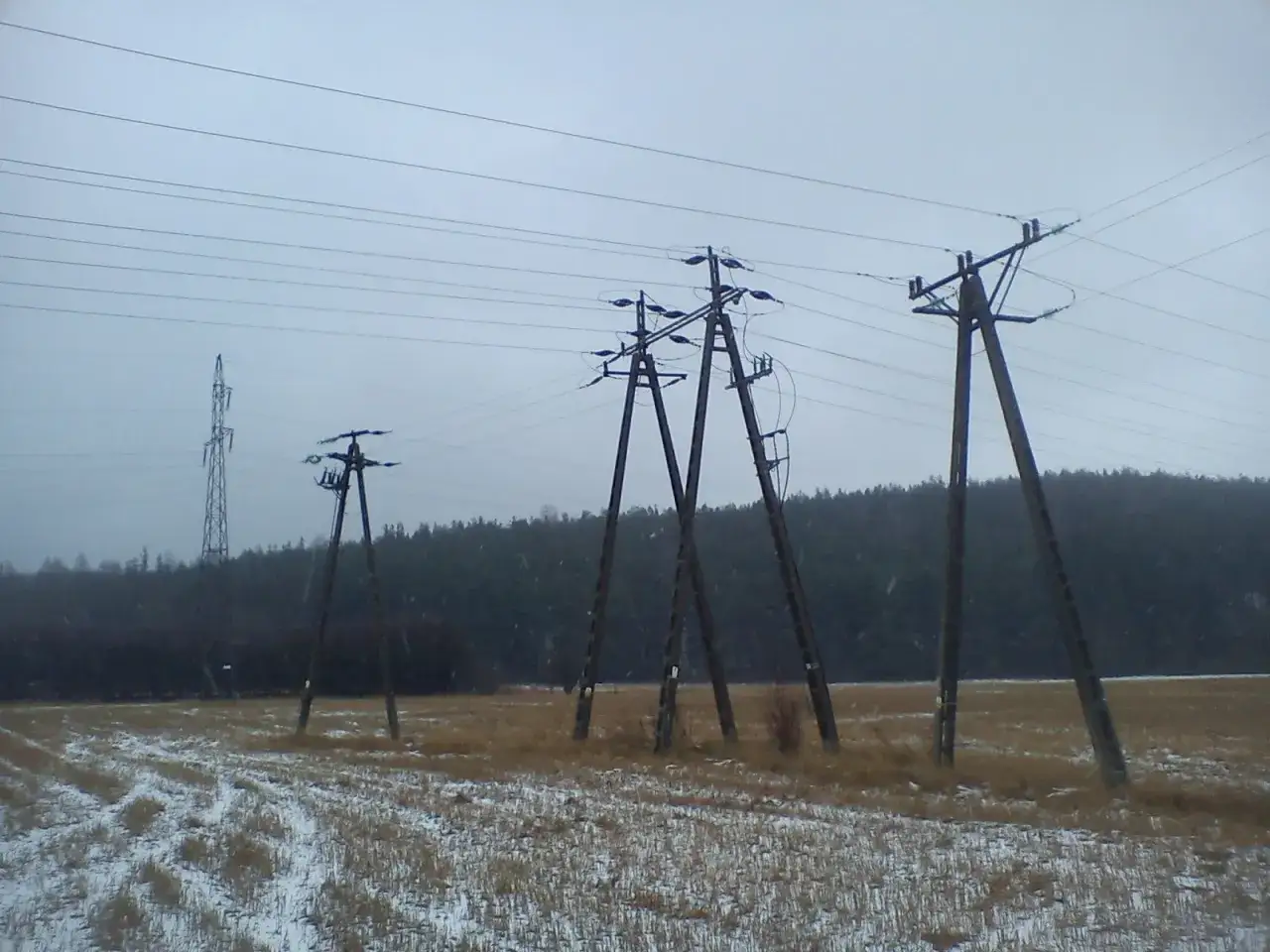 Zimowy krajobraz z linią energetyczną. Czy ktoś dostał odszkodowanie za słupy energetyczne?
