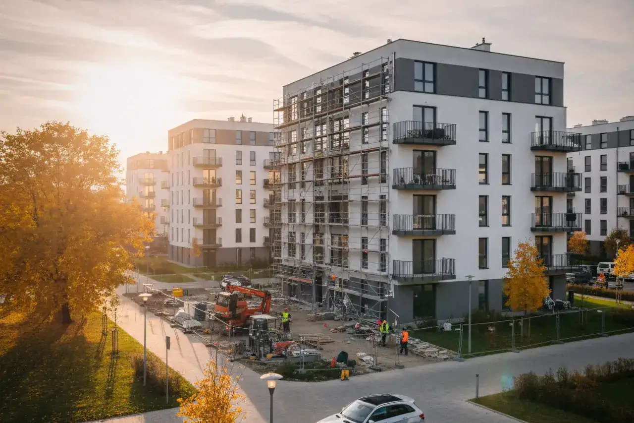 Budowa osiedla, jesienne słońce. Zastanawiasz się, jak sprawdzić dewelopera przed podpisaniem umowy? Sprawdź jego realizacje.