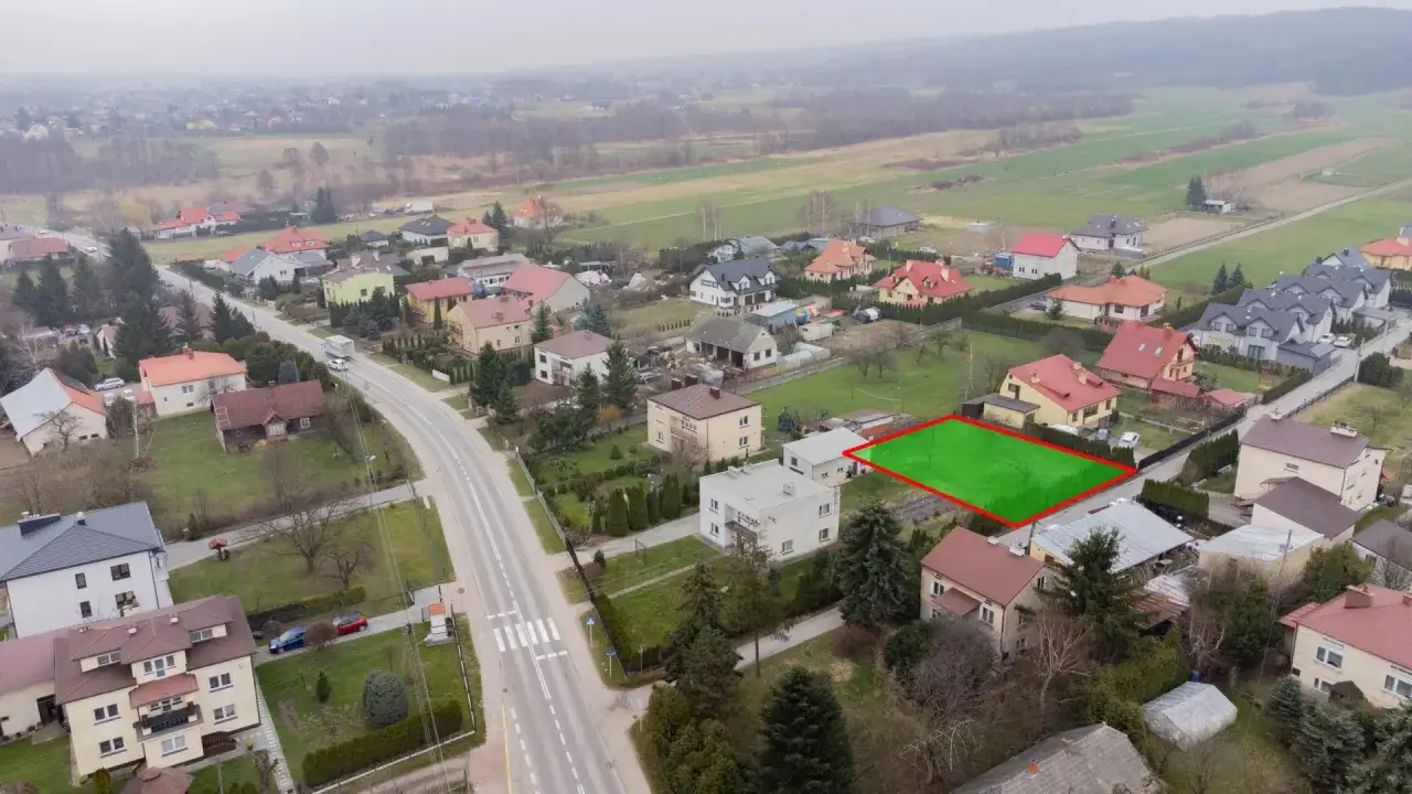 Działka z zaznaczonymi granicami, otoczona domami jednorodzinnymi. Idealne miejsce na budowę, blisko terenów zielonych, gdzie kiedyś były klasy ziemi rolnej.