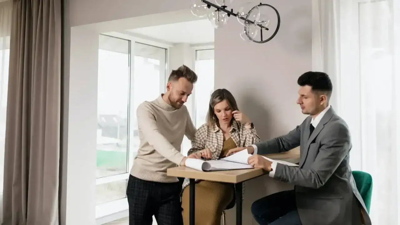 Para omawia z agentem nieruchomości plany domu, zastanawiając się, ile zarabia agent nieruchomości.